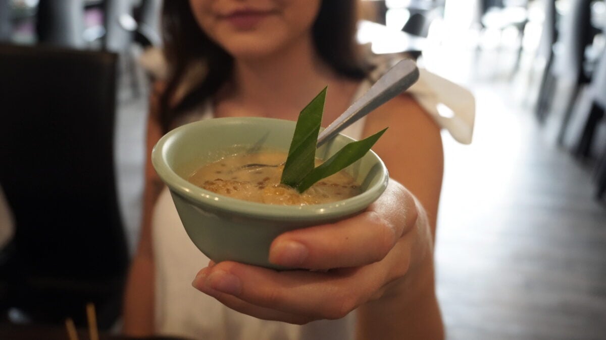 Girl holds bowl of food on Eat Drink Georgetown Food Tour in Penang